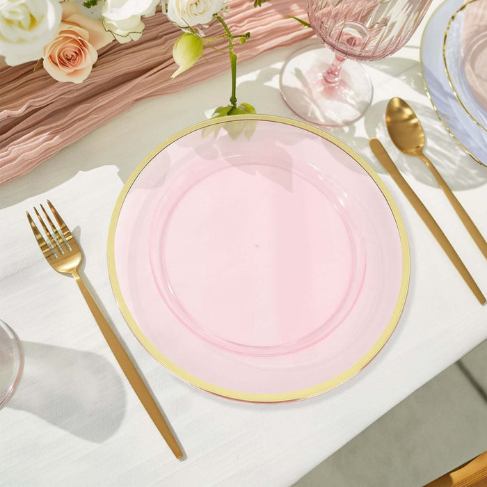 Pink glass plate with gold rim on a beautifully set table.