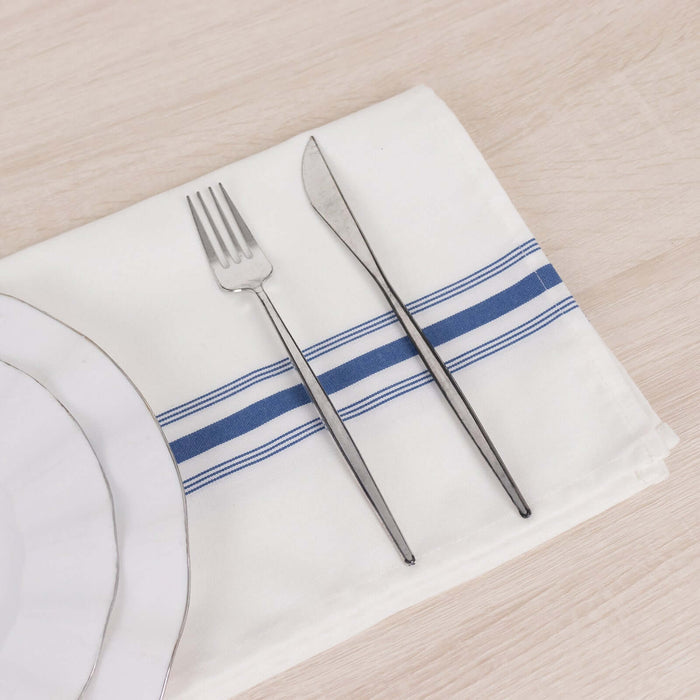 Silver cutlery on a white napkin with blue stripes.