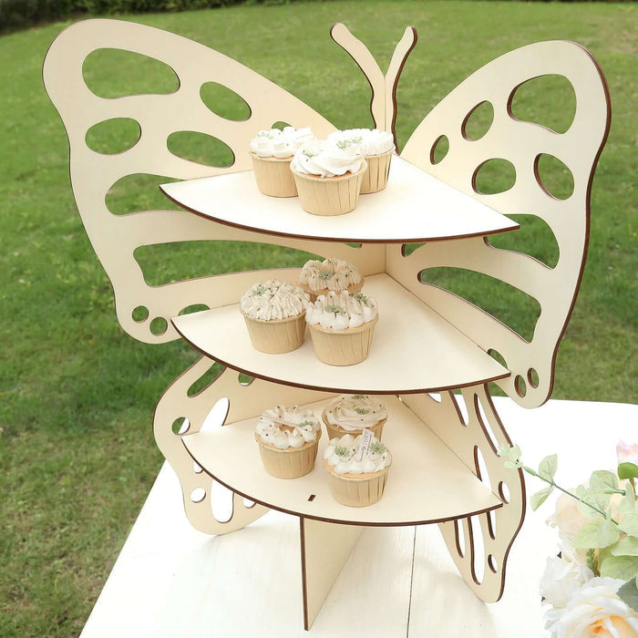 Butterfly-shaped cupcake stand with decorated cupcakes in a garden setting.
