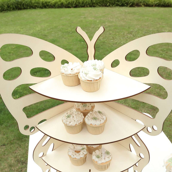 Butterfly-shaped cupcake stand with decorated cupcakes outdoors.