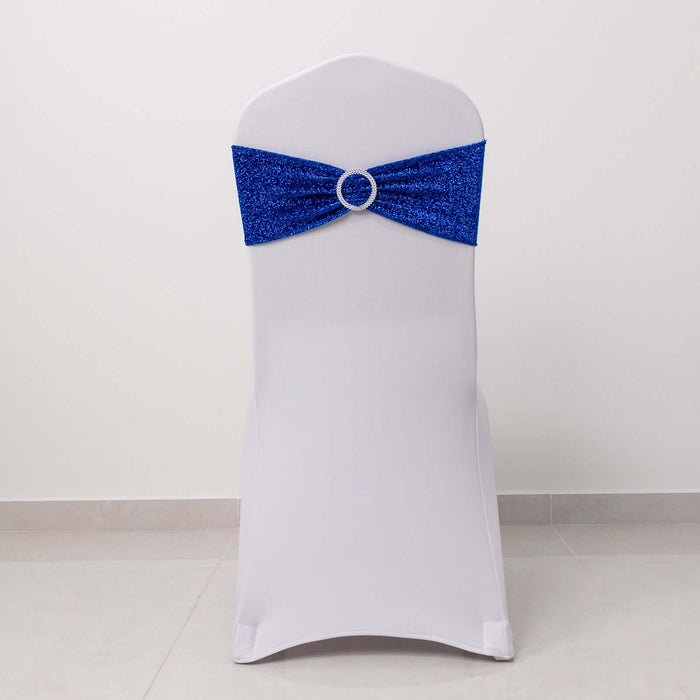 White chair cover with blue sequin sash and silver ring detail.