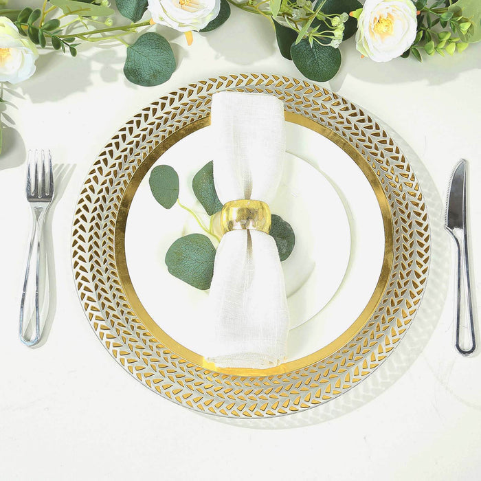Elegant gold and white dinner plate set with napkin and cutlery on a table.