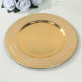 Gold decorative plate with intricate textured rim on a plain surface.