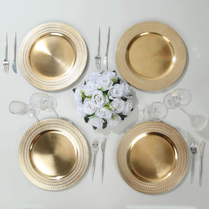 Elegant gold charger plates with white rose centerpiece on a table setting.