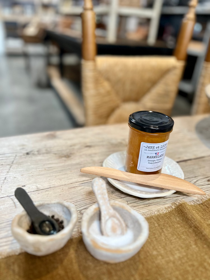 Handmade salt and pepper set: small ceramic bowls with spoons and a refill jar on table
