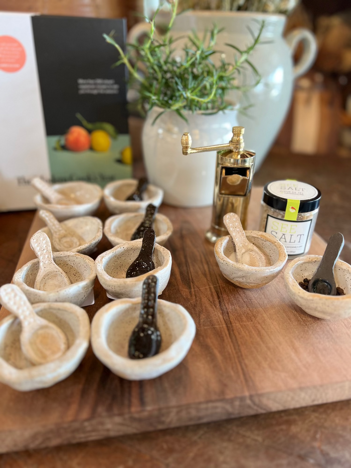 Handmade salt and pepper set: several ceramic bowls with speckled white finish and spoon scoops