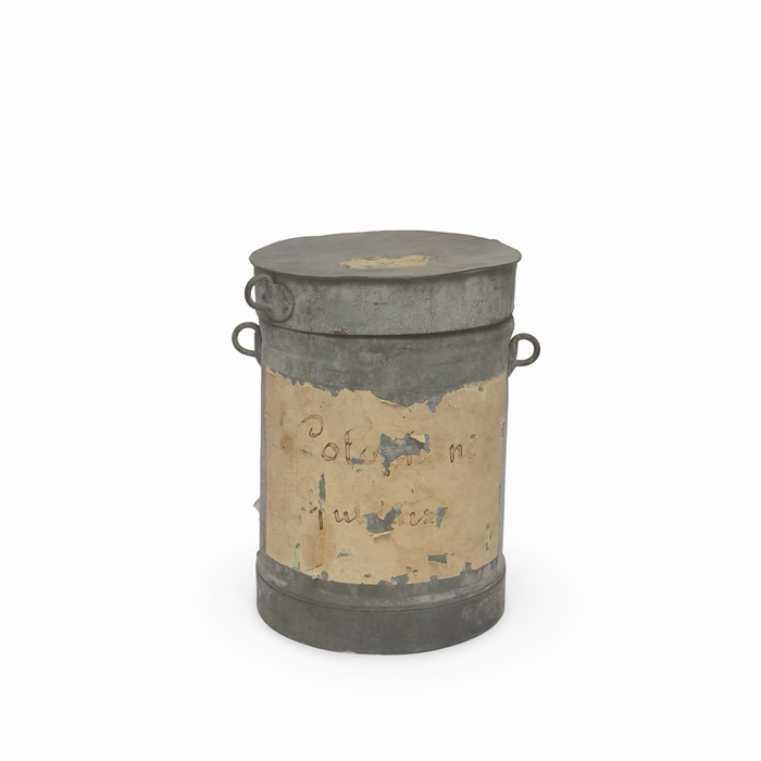 Weathered metal canister with flat lid, side handles, and tan decorative painted panel