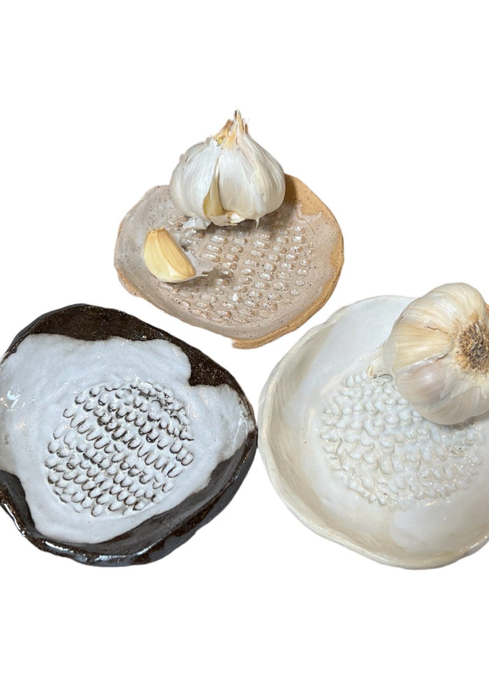 Round ceramic graters set with garlic cloves, black and white textured grating discs