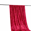 Red velvet fabric draped on a rod, showcasing its rich texture and color.