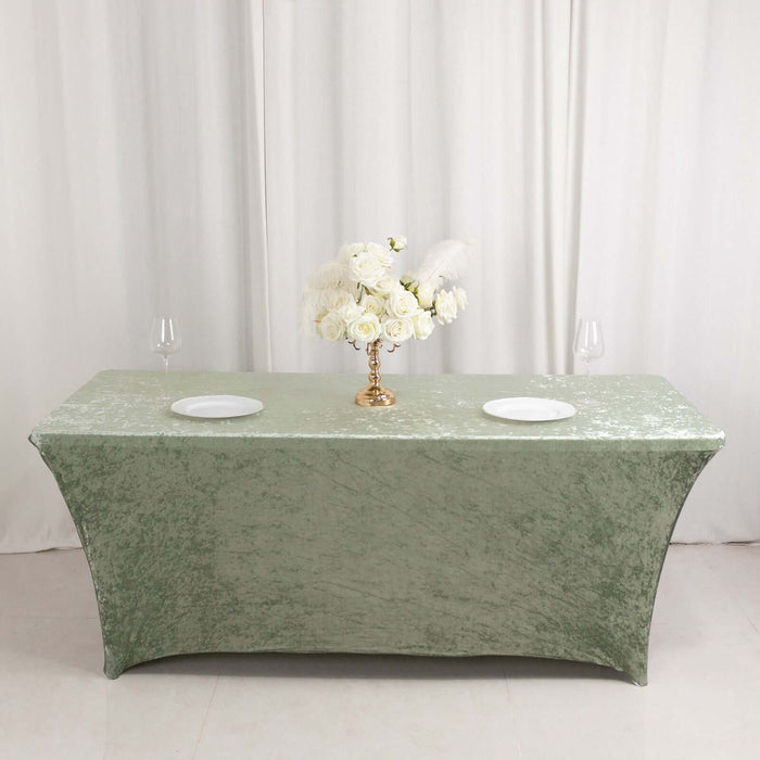 Green velvet tablecloth with floral centerpiece and plates.