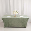 Green velvet tablecloth with floral centerpiece and plates.