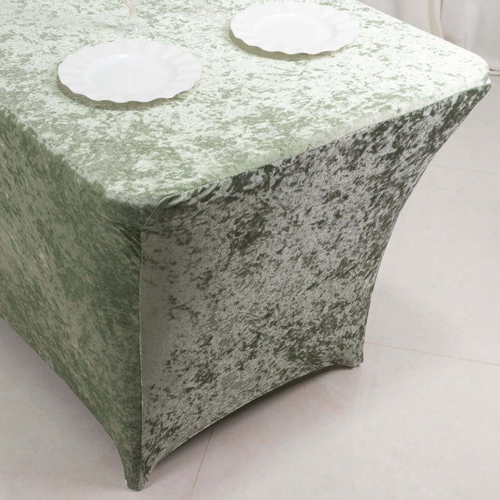Green velvet tablecloth draped over a table with decorative plates.