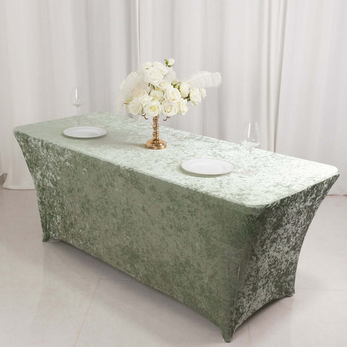 Elegant green tablecloth styled with white floral centerpiece and dinnerware.