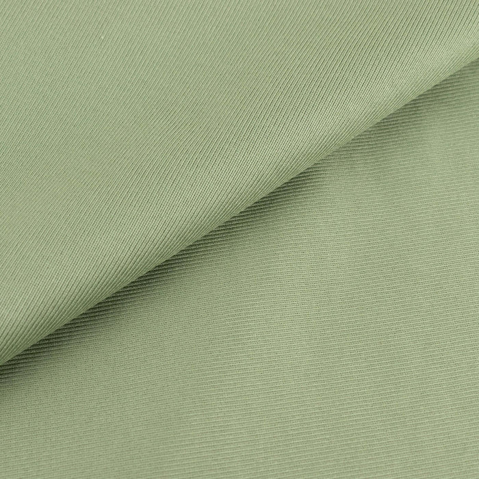 Green textured fabric with a smooth finish and subtle ribbing details.