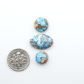 Golden Hills Turquoise cabochons, icy blue to lavender tones with chocolate matrix, polished stones on a white background with a US dime for scale
