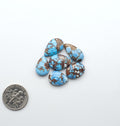 Golden Hills Turquoise cabochons, icy blue to lavender tones with chocolate matrix, polished stones on a white background with a US dime for scale