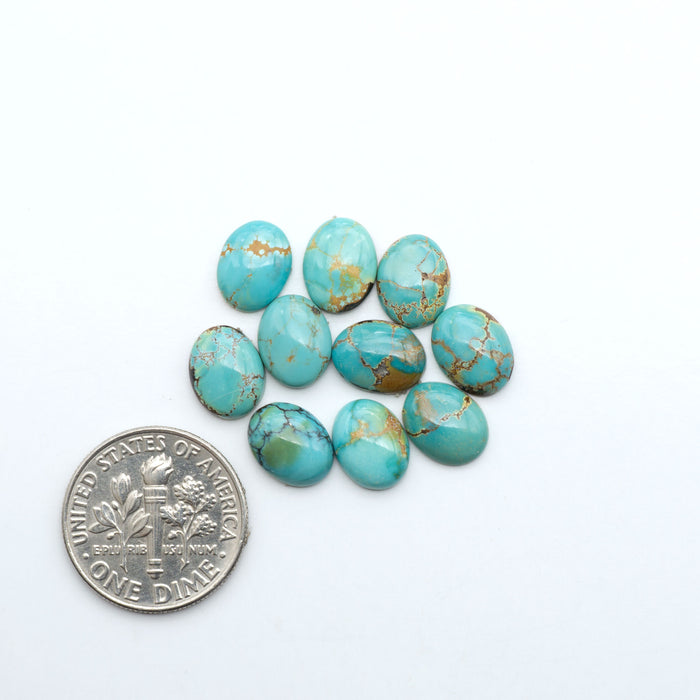 Hubei Cloud Mountain Turquoise cabochons, blue and green color with black matrix, polished stones on a white background with a US dime for scale