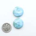 Larimar stone cabochons, cut and polished, blue and white gemstones on a white background, with a US dime for scale