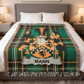 Mann Irish woven blanket with family crest and Irish National Tartan displayed on a bed