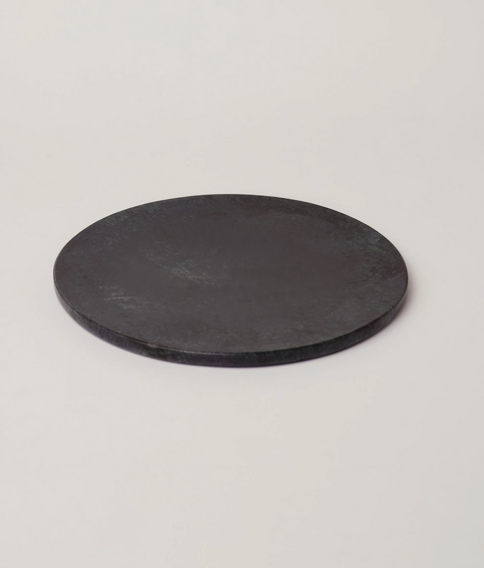 Round deep green marble serving platter with smooth surface and subtle dark veining