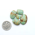 Number 8 Turquoise cabochons, blue and green color with brown matrix, polished stones on a white background, with a US dime for scale