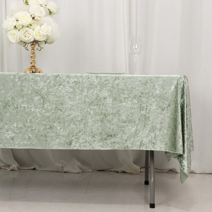 Green velvet tablecloth draped elegantly over a table with floral centerpiece.