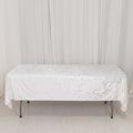 White sequin tablecloth draped over a folding table in a studio setting.