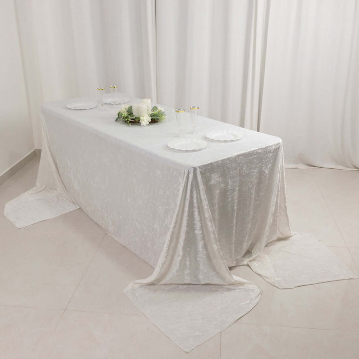 Elegant white table setup with plates and floral decor.
