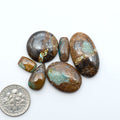 Royston Turquoise cabochons, blue-green color with natural matrix, polished stones on a white background, with a US dime for scale