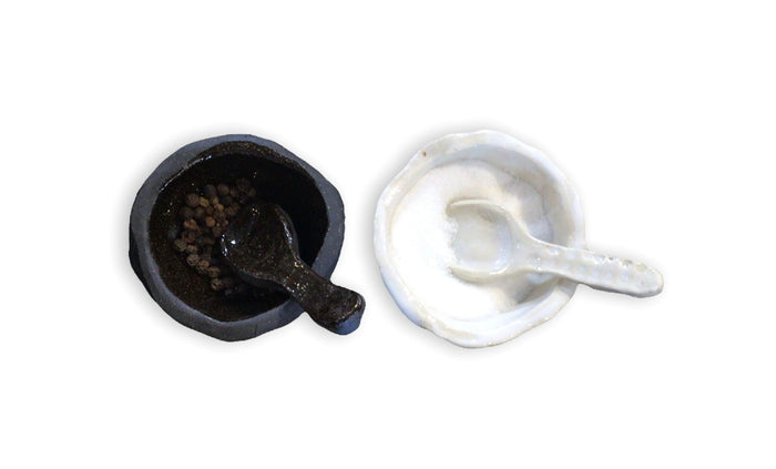 Handmade salt and pepper set with dark and light ceramic bowls plus matching serving spoons