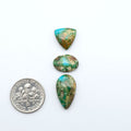 Sonoran Mountain Turquoise cabochons, blue-green color with natural matrix, polished stones on a white background, with a US dime for scale
