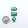 Sonoran Mountain Turquoise cabochons, blue-green color with natural matrix, polished stones on a white background, with a US dime for scale