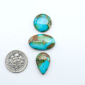 Sonoran Mountain Turquoise cabochons, blue-green color with natural matrix, polished stones on a white background, with a US dime for scale