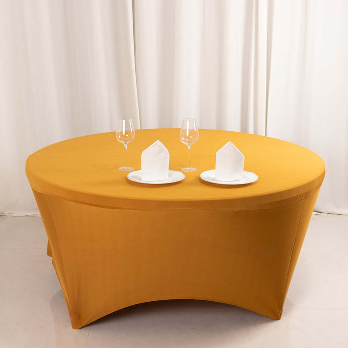Round yellow table with white plates and glasses set for dining.