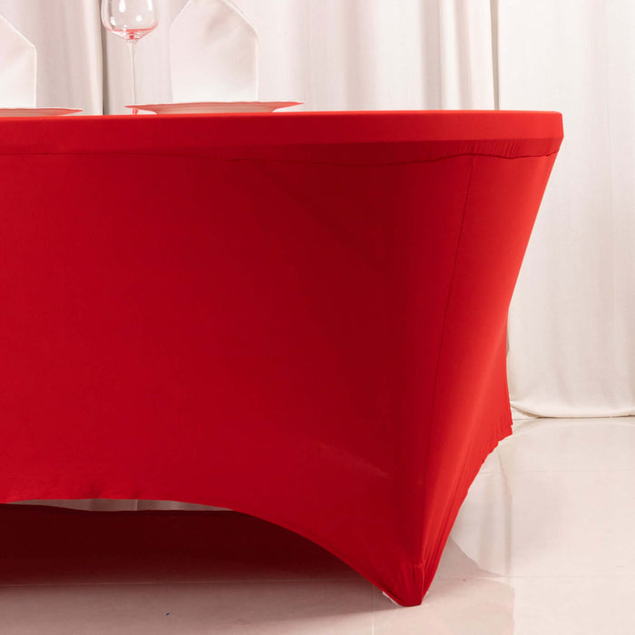 Red table cover draped over a table corner in a studio setting.