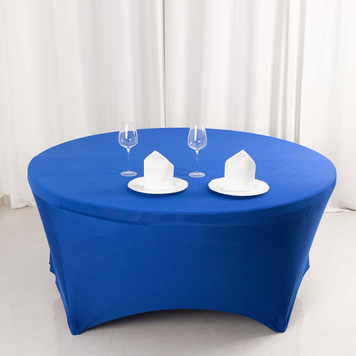 Blue round table with white plates and glasses, set for dining.