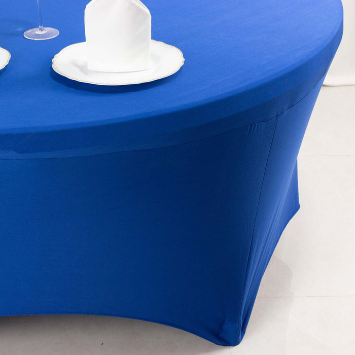 Blue table cover on a round table with white plates and napkins.