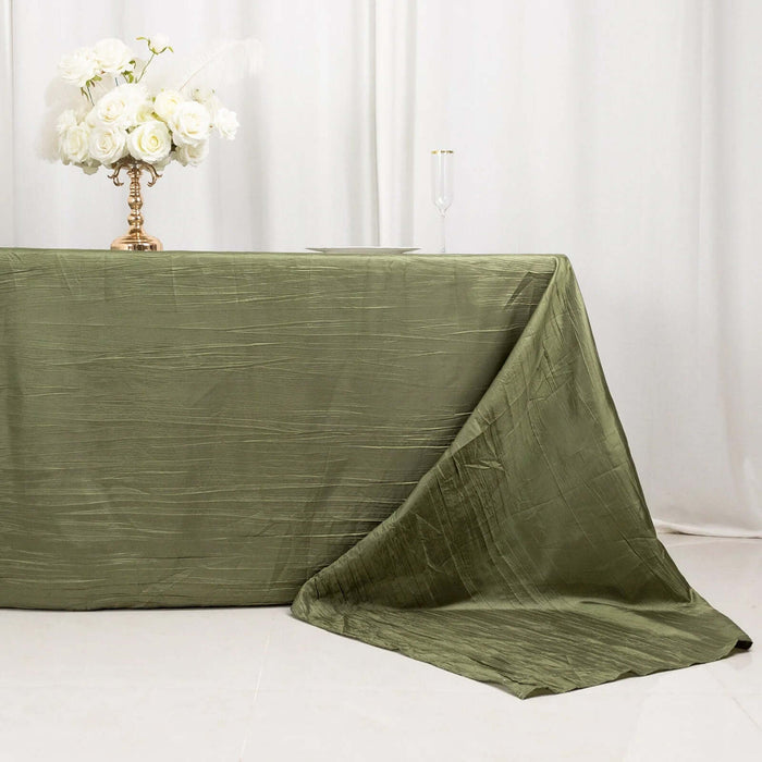 Olive green tablecloth draped elegantly over a table with floral centerpiece.