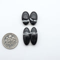 White Buffalo stone cabochons, white stone with black matrix, polished stones on a white background, with a US dime for scale