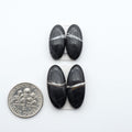 White Buffalo stone cabochons, white stone with black matrix, polished stones on a white background, with a US dime for scale